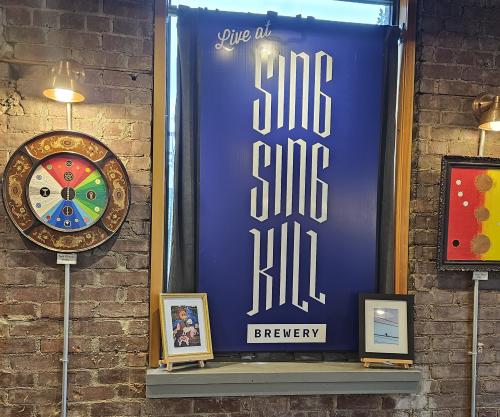 A blue sign that says Sing Sing Kill Brewery.