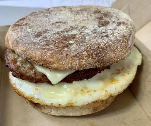 An egg sandwich on an English muffin with a sausage patty and a slice of cheese from the Cog Railway