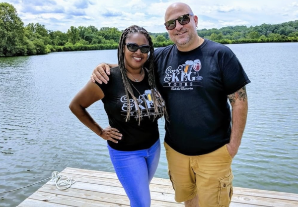 Renee and Don Ventrice of Cork & Keg Tours stand on a dock overlooking a lake in Loudoun County