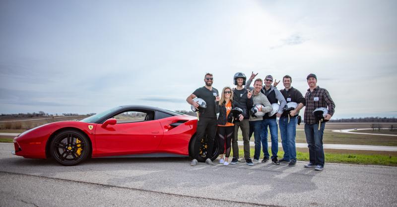 Group of people around race car on track