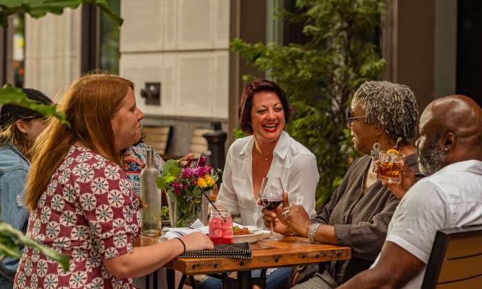 Friends enjoying drinks and dinner outside of Bourbon