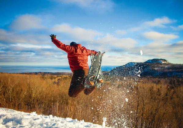person in snowshoes jumping