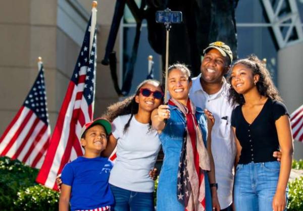 A family in front of Iron Mike at ASOM taking a selfie