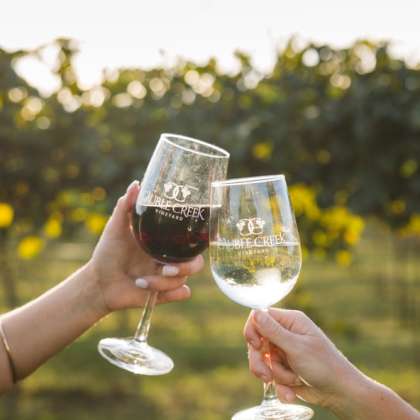 Two wine glasses from Cauble Creek Vineyard "cheersing"