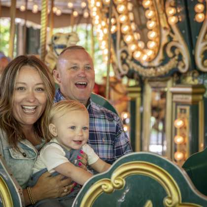 Family on carousel at Dan Nicholas Park
