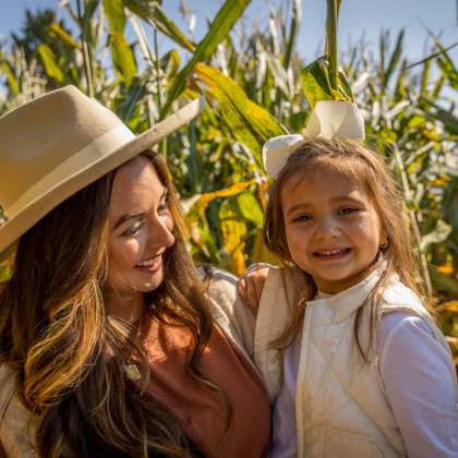 Mom holding daughter in corn maze
