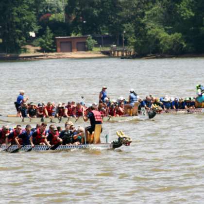 Two long dragon boat canoes racing down lake