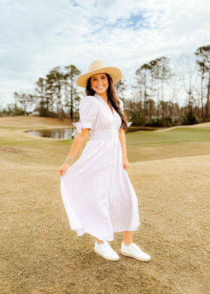 Woman Dressed for the Masters Tournament in striped midi dress and straw hat from The Swank Company