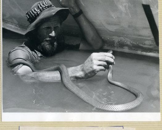man in water with snake