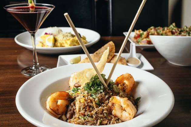 Plate of food with shrimp rice and red wine on the side