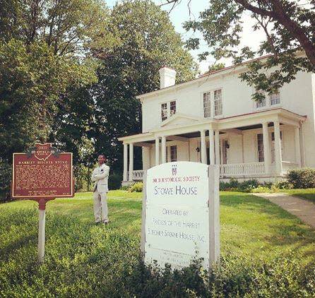 Historic signs and a man in front of the Harriet Beecher Stowe House in Cincinnati, Ohio