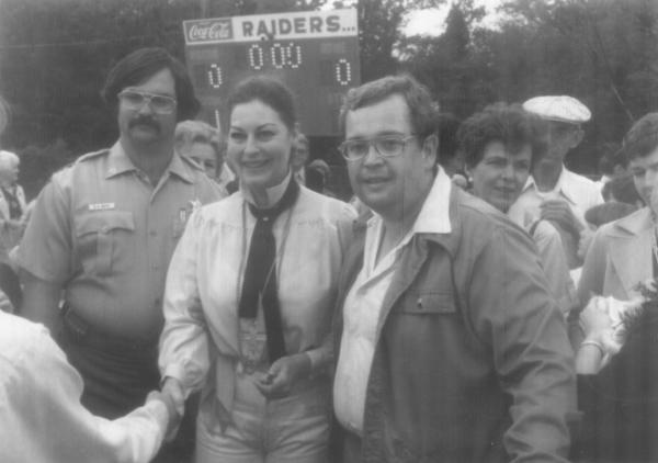 Ava shaking hands with someone and standing next to Dewey Sheffield.