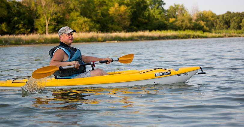 A man kyacks across one of the lakes in Busse Woods