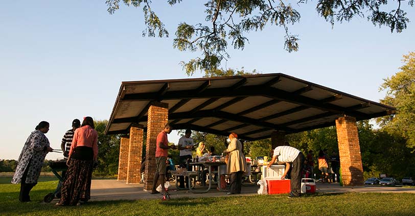 A shady and large ramada with people having a picnic in Busse Woods