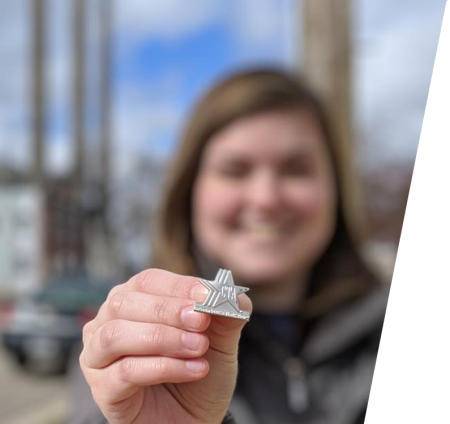 Person holding the Certified Tourist Ambassador Pin