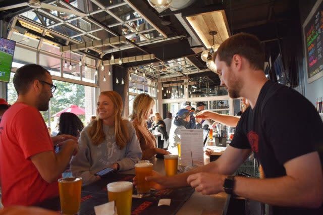 bartender serving woman beer at StillFire Brewing