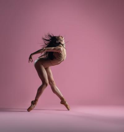 Ballet dancer in pose with pink background