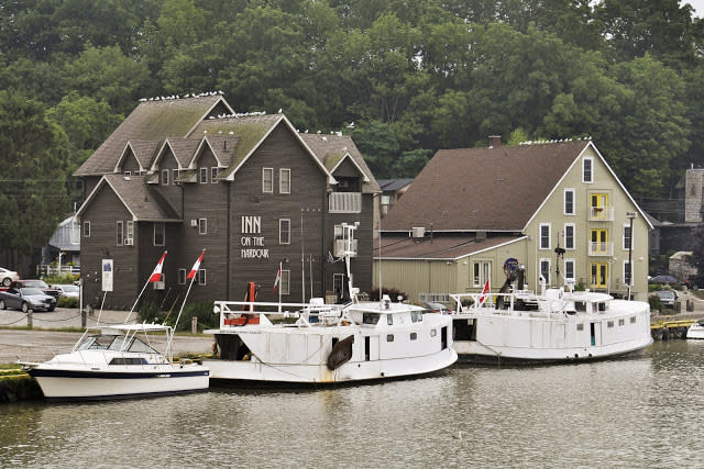 Inn on the Harbour building sitting above the water with two boats in front