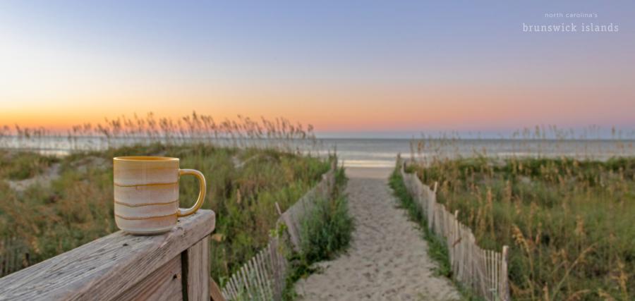 Coffee cup on beach path at sunrise