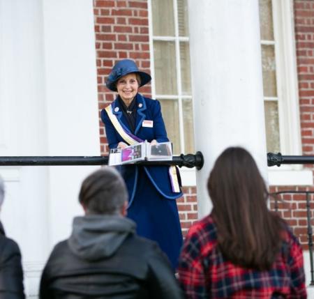 a woman dressed in period clothing giving a walking tour