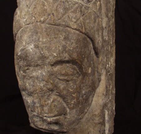 A very old stone carving of a medieval woman.