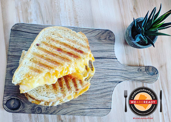 Grilled cheese sandwich on cutting board with LoudounIsReady icon and #LoveLoudounFood