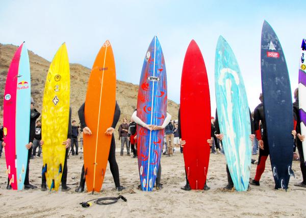 Surfers holding up colorful surfboards at Mavericks Beach