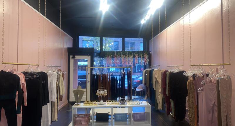 Room with pink walls and clothing racks with dresses