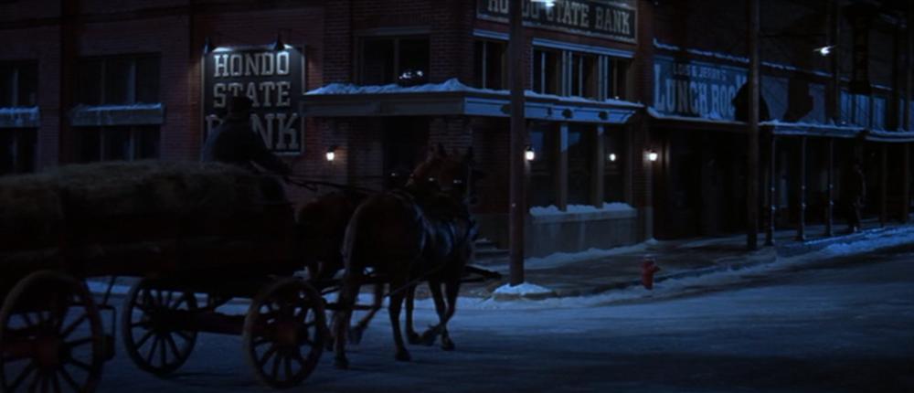 The Newton Boys screengrab showing a horse-drawn carriage in front of the Bartlett National Bank with signs reading Hondo State Bank