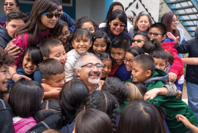 Principal Antonio Trujillo gets a surprise hug from student at St. Joseph Mission School