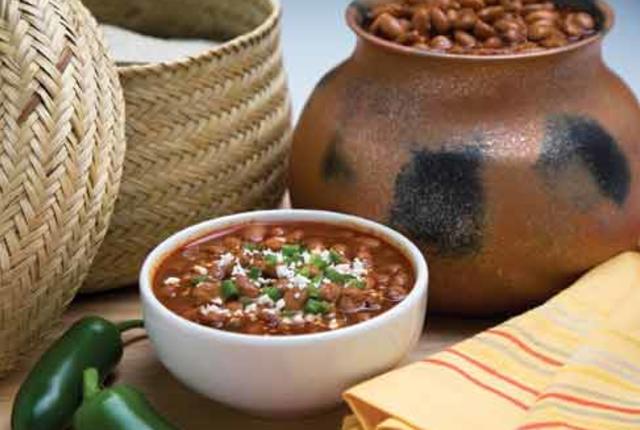 Bowl of beans in front of a clay pot of beans