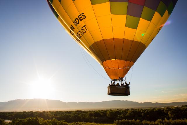 A hot air balloon floating with views of the mountains in the background