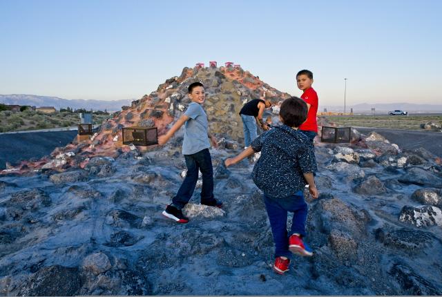 Family members hike up the manmade volcano on Albuquerque's west side, New Mexico Magazine