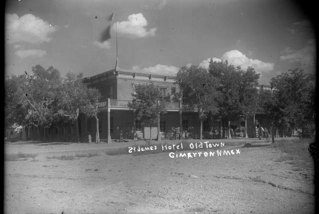 A black and white photo of a two-story hotel in Cimarron, New Mexico.