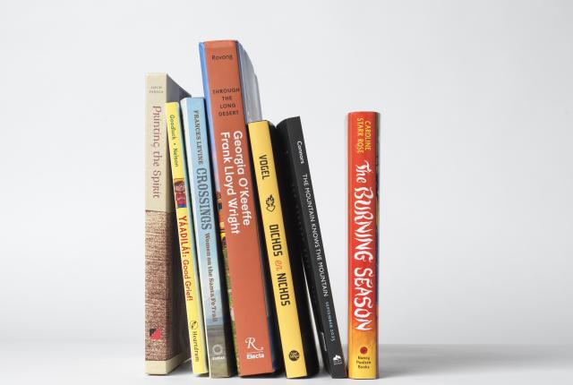 Stack of books by New Mexico authors featured in New Mexico Magazine's 2025 reading list.