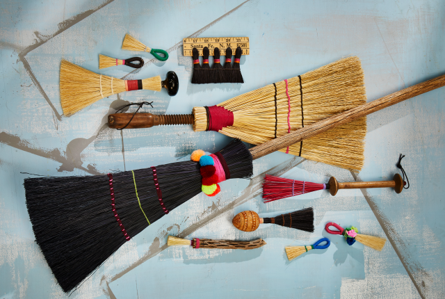 Different sized brooms and brushes made by Julia Tait Dickerson.
