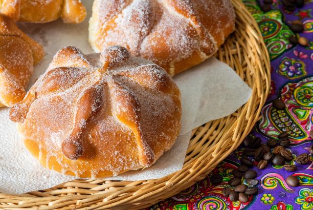 Traditional pan de muerto on a woven plate.