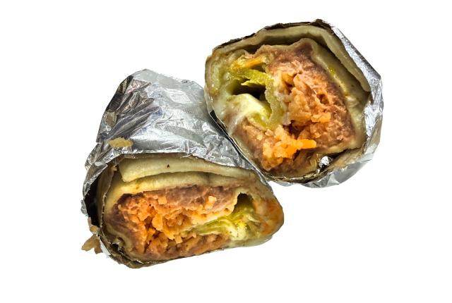 A foil-wrapped burrito cut into two halves.