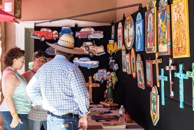 A booth at the Corrales Harvest Festival showcases several colorful retablos.