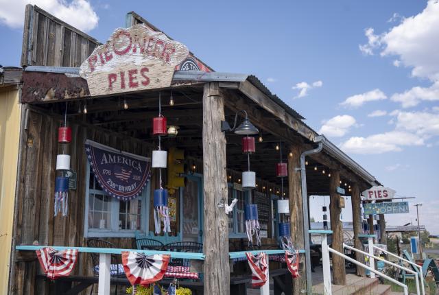 Rustic pie shop porch decorated with bunting and hanging lights.