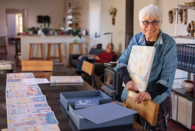 Judy Tuwaletstiwa reviewing pages from her book "Chaco Series"
