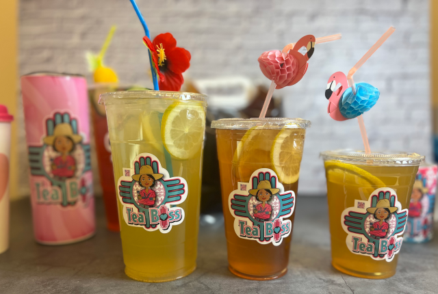 A colorful lineup of Tea Boss drinks with custom stickers and playful garnishes.