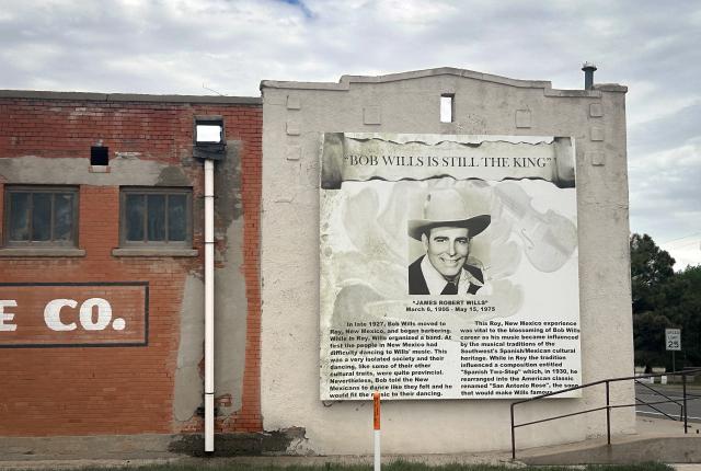 Outdoor mural featuring a portrait and biography of Bob Wills on the side of a building.