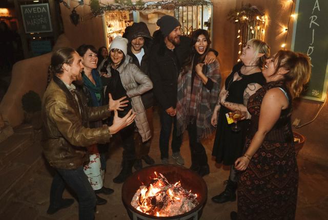Revelers warm up during Bonfires on Bent Street, in Taos.