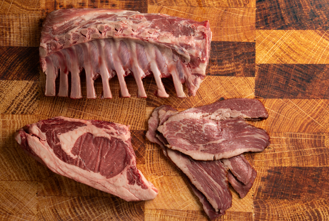 Close-up of premium raw meat cuts, including rib back and marbled steaks.