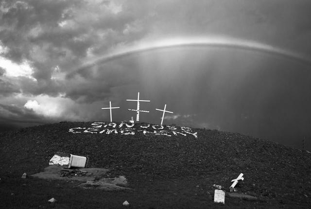 Black and white photograph of a cemetery in Albuquerque with a rainbow over it.