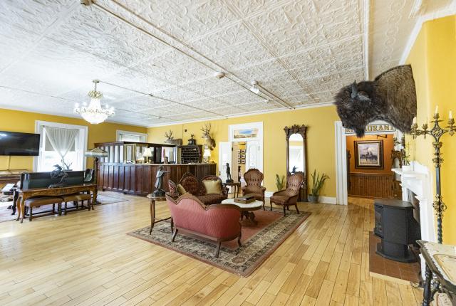 Elegant sitting room at the St. James Hotel with yellow walls, antique furniture, and tin ceilings.