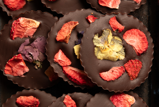 Ek.Chuah chocolate discs are decorated with strawberries and violet petals.