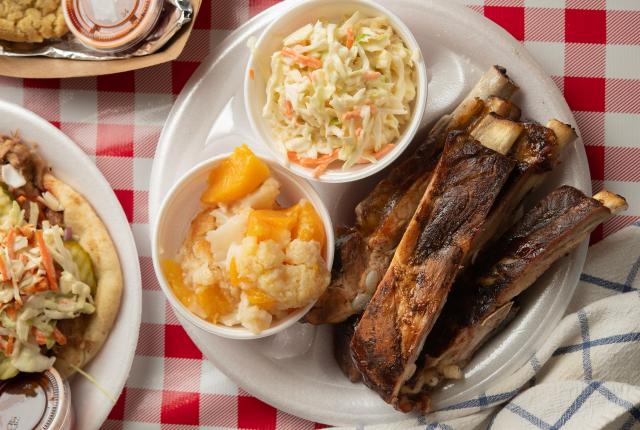 A plate of spare ribs with peach cobbler and coleslaw from Watson's BBQ.