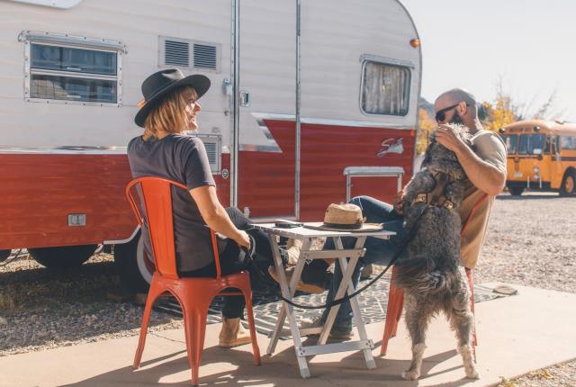 Outside a 2015 reproduction of a 1961 Shasta Airflight Camper, guests enjoy the pet-friendly grounds.